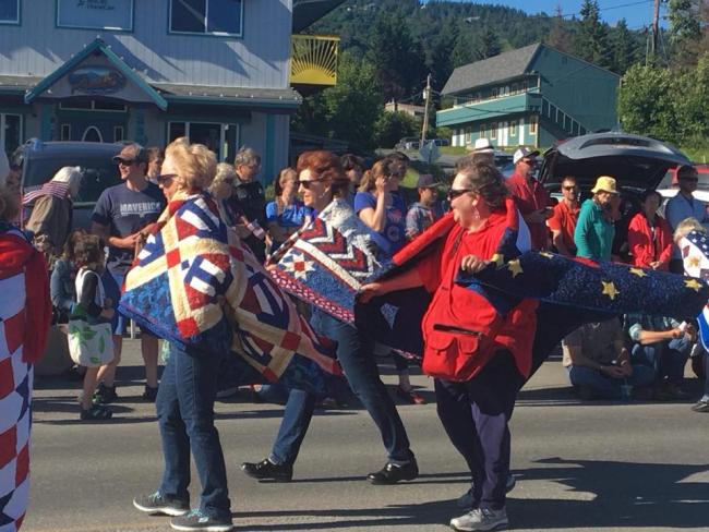 Charlene, Patrice, and Linda with their Quilts of Valor on their shoulders in the 4th of July parade